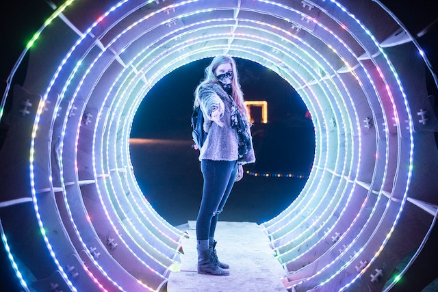 A person inside a circular portal holding their hand out to the viewer